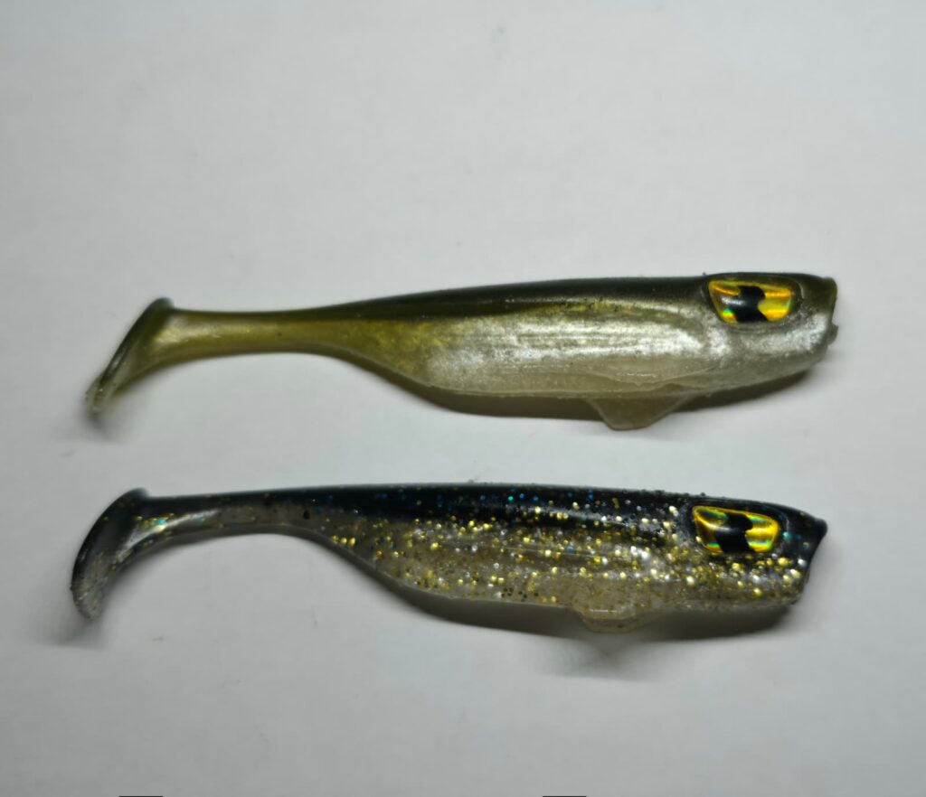 Zwei Banks Maverick Gummiköder in den Farben Mossback Silver und Diamond Flash mit Schaufelschwanz und 3D-Augen